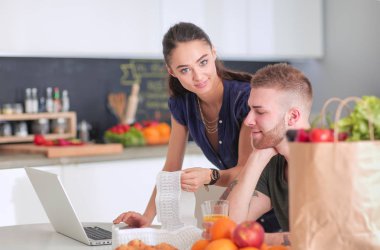 Çift evde mutfak içinde laptop ile onların fatura ödeme