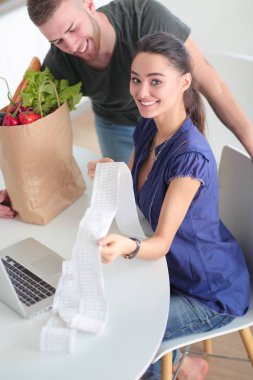 Çift evde mutfak içinde laptop ile onların fatura ödeme