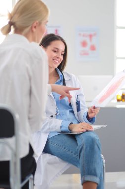 Doktor ve hasta masada otururken bir şey tartışıyorlar. İlaç ve sağlık hizmetleri kavramı