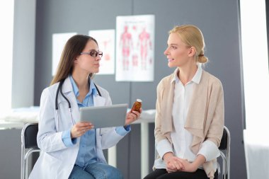 Doktor ve hasta masada otururken bir şey tartışıyorlar. İlaç ve sağlık hizmetleri kavramı