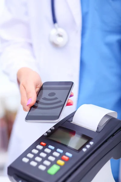 O médico está a segurar o terminal de pagamentos nas mãos. A pagar por cuidados de saúde. Doutor... — Fotografia de Stock