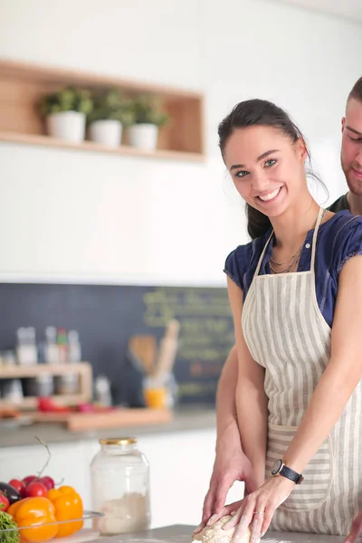 Jovem casal preparado bolo de pé na cozinha — Fotografia de Stock