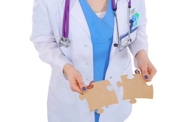 Donna medico in possesso di due pezzi di puzzle di collegamento — Foto Stock