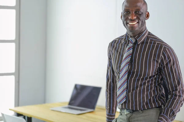 Retrato de um belo homem de negócios negro em pé no cargo — Fotografia de Stock