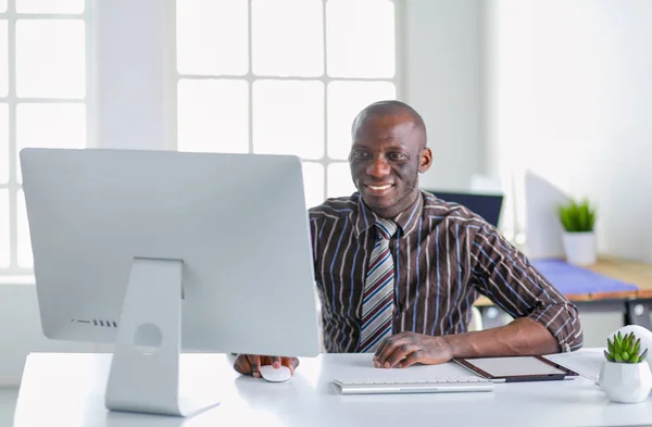 Handsome afro american businessman in classic suit is using a laptop and smiling while working in office — Stock Photo, Image