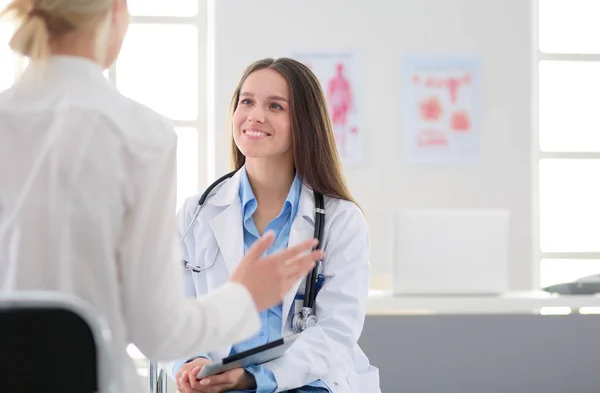 Médico e paciente discutindo algo enquanto se senta na mesa. Conceito de medicina e cuidados de saúde — Fotografia de Stock