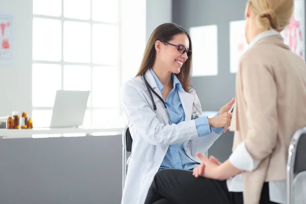 Médico e paciente discutindo algo enquanto se senta na mesa. Conceito de medicina e cuidados de saúde — Fotografia de Stock