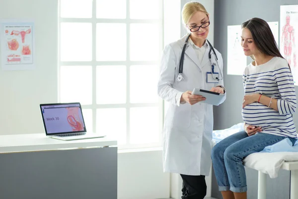 Beautiful smiling pregnant woman with the doctor at hospital — Stock Photo, Image