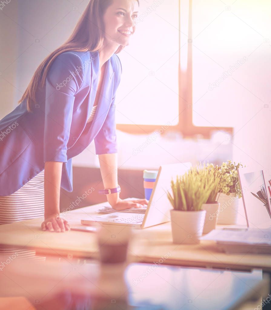 Portrait of a beautiful business woman standing near her workplace