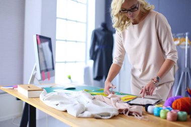 Moda tasarımcısı kadın stüdyoda tasarımları üzerinde çalışıyor..