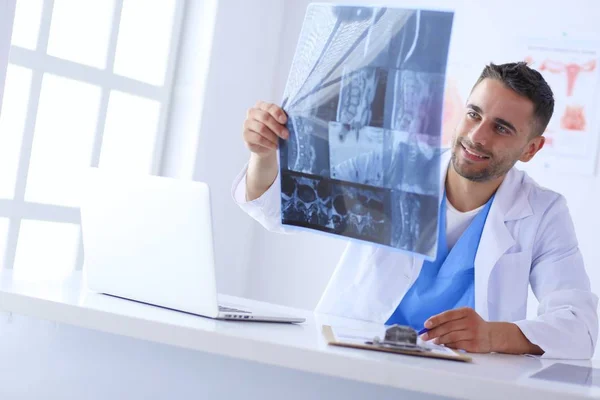 Schöner Arzt spricht mit junger Patientin und macht sich Notizen, während er in seinem Büro sitzt. — Stockfoto