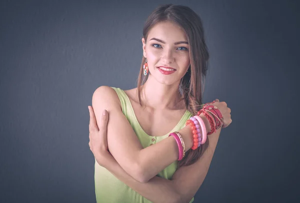 Portret van een jonge glimlachende vrouw op een grijze achtergrond — Stockfoto