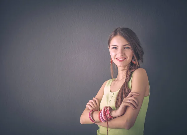灰色の壁の背景に若い笑顔の女性の肖像画 — ストック写真