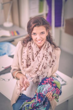 Stüdyoda çalışan genç kadın moda tasarımcısı.