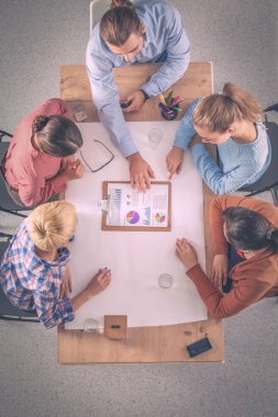 İş adamları toplantıda, ofiste oturup tartışıyorlar.