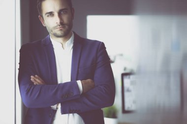 Dizüstü bilgisayar ve bilgisayar çalışırken önünde genç tasarımcı portresi.