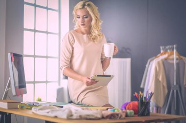 Moda tasarımcısı kadın stüdyoda tasarımları üzerinde çalışıyor..