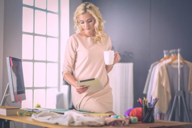 Moda tasarımcısı kadın stüdyoda tasarımları üzerinde çalışıyor..