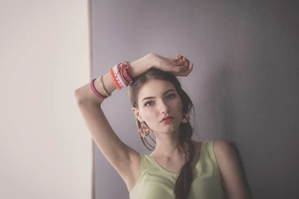 Retrato de uma jovem mulher sorridente em um fundo de parede cinza — Fotografia de Stock