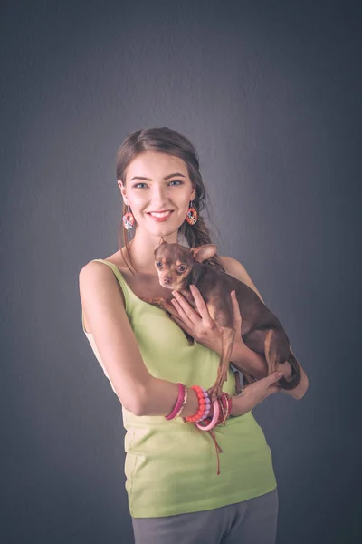Retrato de la hermosa joven con perro sobre el fondo gris — Foto de Stock