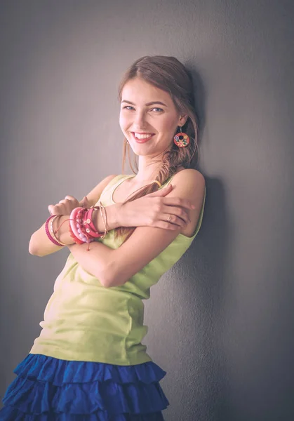 Retrato de una joven sonriente sobre un fondo de pared gris — Foto de Stock