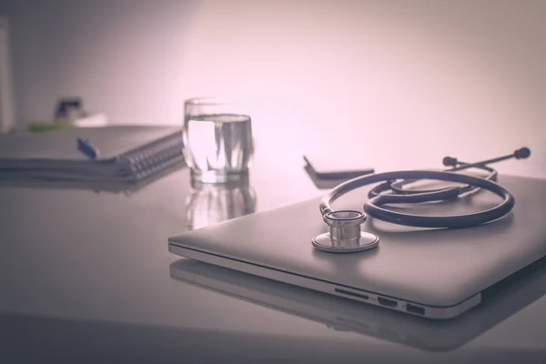 Laptop com pilha de pastas na mesa sobre fundo branco — Fotografia de Stock