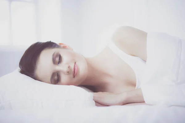 Молодая красивая женщина лежит в постели. — стоковое фото