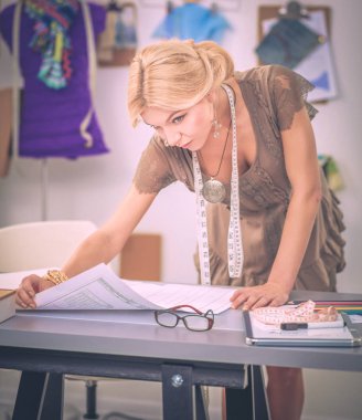 Stüdyoda çalışan genç kadın moda tasarımcısı..
