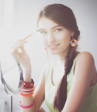 Genç güzel kadın ayna, Masa başında oturan yakınındaki makyaj yapma