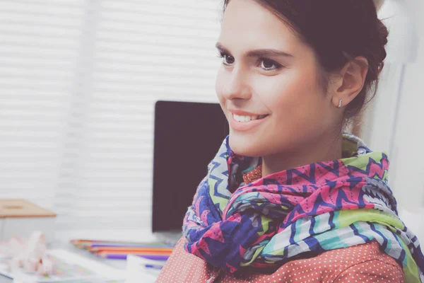 Beautiful fashion designer sitting at the desk in studio — Stock Photo, Image