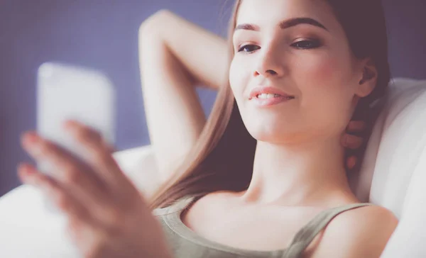 Pretty woman in her living room lying on the couch sending mess — Stock Photo, Image