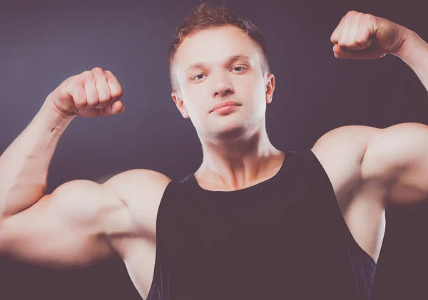 强壮英俊的年轻健美运动员展示他的肌肉和二头肌 — 图库照片