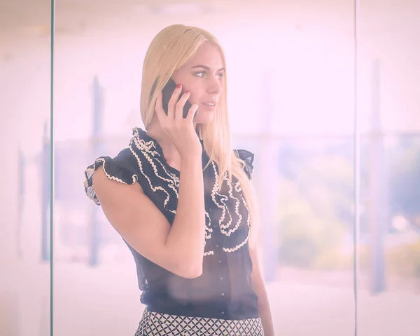 Een mooie blonde zakenvrouw is aan de telefoon.. — Stockfoto