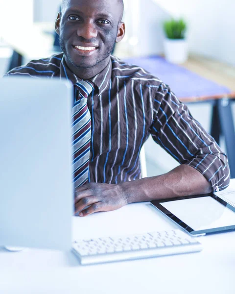 클래식 슈트에 잘생긴 아프리카 미국 실업가 노트북을 사용 하 고 사무실에서 작업 하는 동안 웃 고 — 스톡 사진