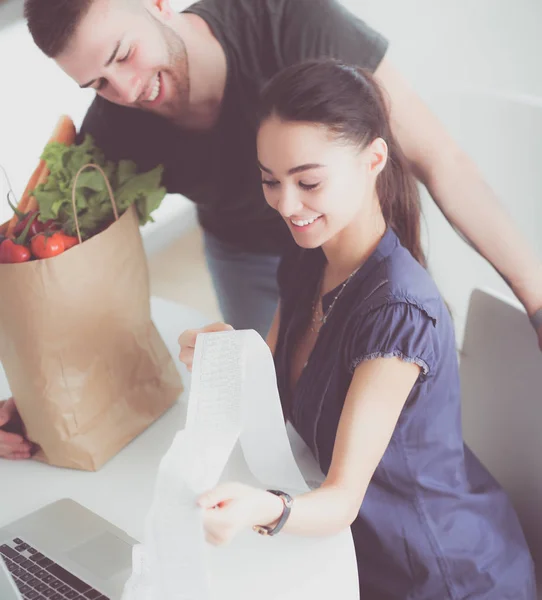 Paret betalar sina räkningar med laptop i köket hemma — Stockfoto