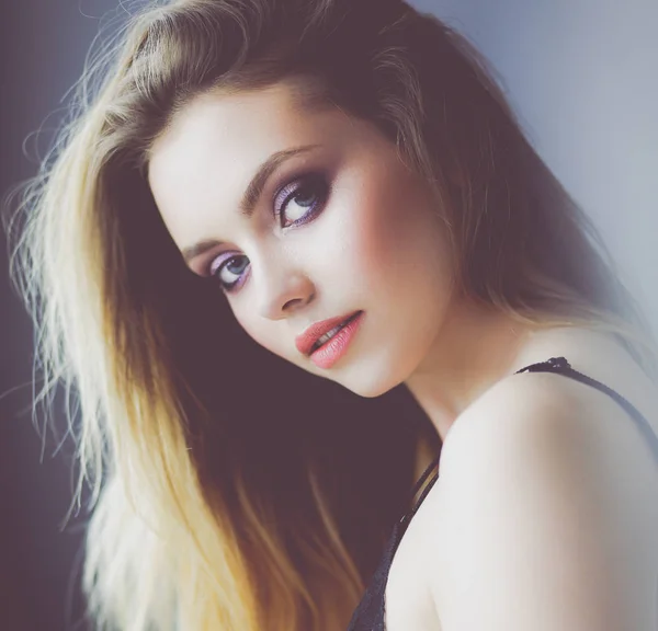 Beautiful young woman lying on white bed — Stock Photo, Image