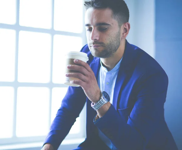 Joven hombre de negocios bebiendo una taza de café o té —  Fotos de Stock