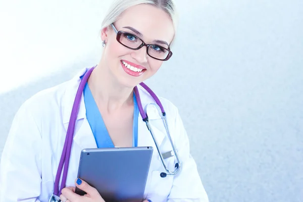 Médica usando um comprimido digital e de pé sobre fundo branco. Mulheres médicas. — Fotografia de Stock