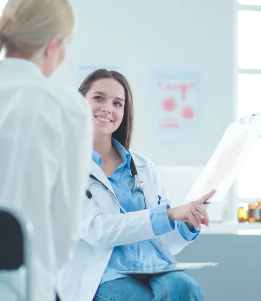 Dokter en patiënt bespreken iets terwijl ze aan tafel zitten. Begrip "geneeskunde en gezondheidszorg" — Stockfoto