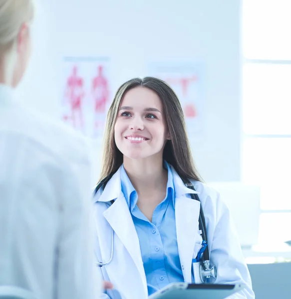 Doktorn och patienten diskuterar något när de sitter vid bordet. Medicin och hälsovård — Stockfoto