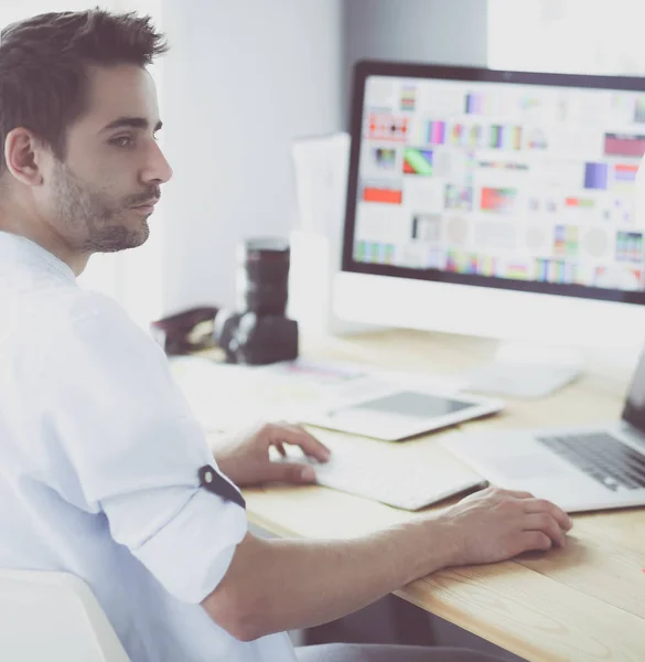 Ritratto di giovane designer seduto allo studio grafico di fronte a laptop e computer mentre lavora online. — Foto Stock