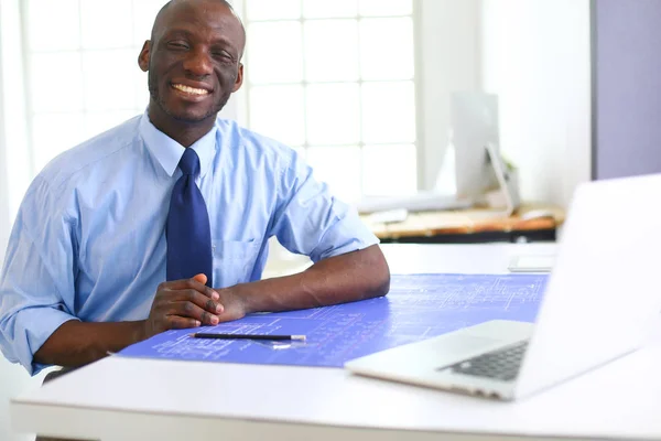 Arquitecto afroamericano trabajando con computadoras y planos en la oficina —  Fotos de Stock