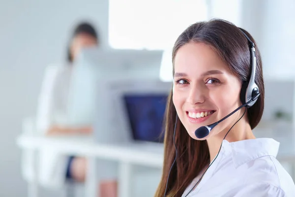 Mujer de negocios sonriente u operador de línea de ayuda con auriculares y computadora en la oficina — Foto de Stock