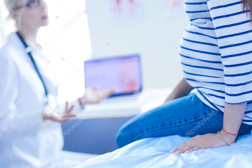 Beautiful smiling pregnant woman with the doctor at hospital