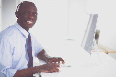 Kulaklıklı Afro-Amerikan işadamı laptopuyla çalışıyor.