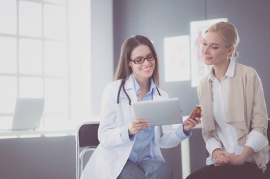 Doktor ve hasta masada otururken bir şey tartışıyorlar. İlaç ve sağlık hizmetleri kavramı