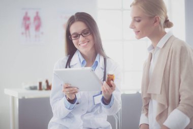 Doktor ve hasta masada otururken bir şey tartışıyorlar. İlaç ve sağlık hizmetleri kavramı