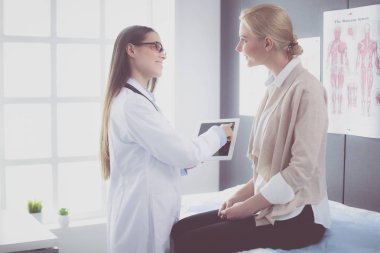 Doktor ve hasta masada otururken bir şey tartışıyorlar. İlaç ve sağlık hizmetleri kavramı