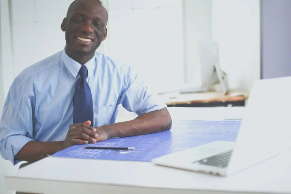 Arquitecto afroamericano trabajando con computadoras y planos en la oficina —  Fotos de Stock