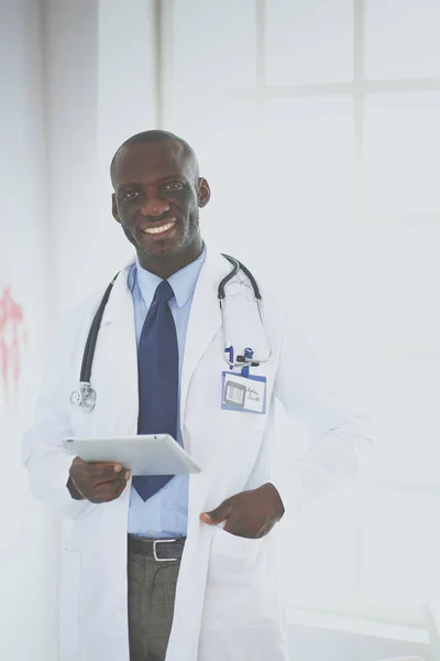 Homem negro médico trabalhador com tablet computador de pé no hospital — Fotografia de Stock